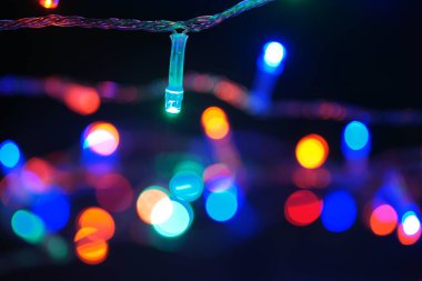 Çok renkli mavi tatil çelengi. Çelenk bulanık. Bir sürü renkli yuvarlak ışık. Tamamen odaklanmış bir fotoğraf. Arka plan ve ön plan bulanık. Tatil havası. Yeni yıl ve Noel yaklaşıyor..