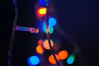 Çok renkli mavi tatil çelengi. Çelenk bulanık. Bir sürü renkli yuvarlak ışık. Tamamen odaklanmış bir fotoğraf. Arka plan ve ön plan bulanık. Tatil havası. Yeni yıl ve Noel yaklaşıyor..