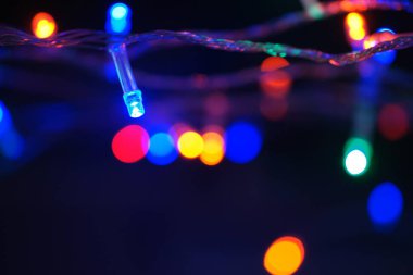 Çok renkli mavi tatil çelengi. Çelenk bulanık. Bir sürü renkli yuvarlak ışık. Tamamen odaklanmış bir fotoğraf. Arka plan ve ön plan bulanık. Tatil havası. Yeni yıl ve Noel yaklaşıyor..