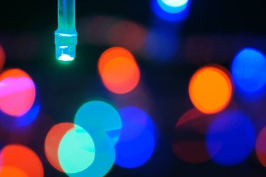 Çok renkli mavi tatil çelengi. Çelenk bulanık. Bir sürü renkli yuvarlak ışık. Tamamen odaklanmış bir fotoğraf. Arka plan ve ön plan bulanık. Tatil havası. Yeni yıl ve Noel yaklaşıyor..