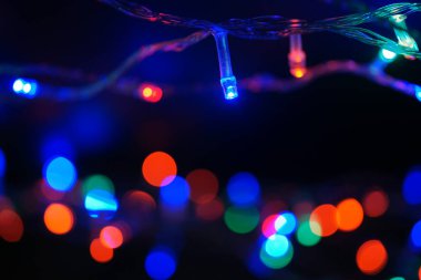 Çok renkli mavi tatil çelengi. Çelenk bulanık. Bir sürü renkli yuvarlak ışık. Tamamen odaklanmış bir fotoğraf. Arka plan ve ön plan bulanık. Tatil havası. Yeni yıl ve Noel yaklaşıyor..