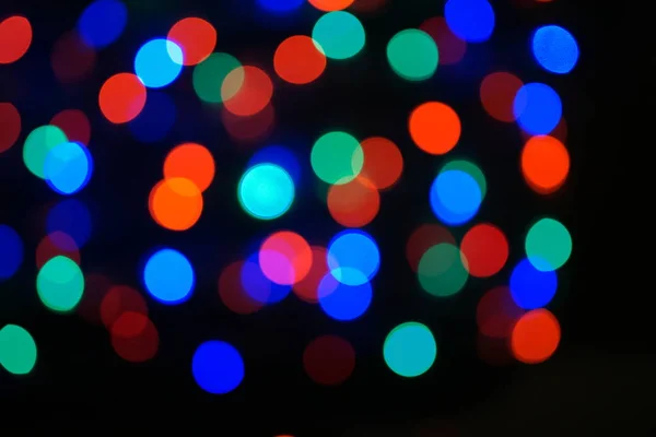 マルチカラーブルーのホリデーガーランド ガーランドはぼやけている 多くの大きなカラフルなラウンドライト 完全に焦点を絞った写真 背景と前景がぼやけています 休日の気分 新年とクリスマスが近づいています — ストック写真