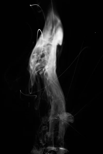 Vape smoke clouds isolated on black background. Hot vape liquid splash in vape coil. Nice aromatic cloud. Low light black and white monochrome photo. Underexposed photo in a low key style.