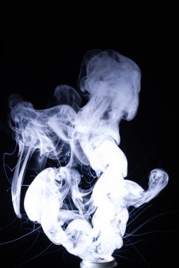 Siyah arka planda izole edilmiş duman bulutları. Vape bobininde sıcak vape sıvısı sıçradı. Güzel aromatik bulut. Düşük ışık fotoğrafı. Düşük tuşlu gizli fotoğraf. 