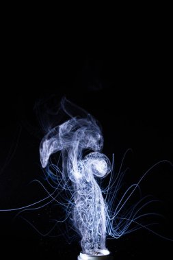 Siyah arka planda izole edilmiş duman bulutları. Vape bobininde sıcak vape sıvısı sıçradı. Güzel aromatik bulut. Düşük ışık fotoğrafı. Düşük tuşlu gizli fotoğraf. 