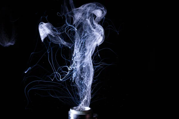 Vape smoke clouds isolated on black background. Hot vape liquid splash in vape coil. Nice aromatic cloud. Low light photo. Underexposed photo in a low key style.