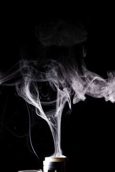 Nuvole vaporizzanti schizzano su sfondo nero. Fumo bianco isolato con glicerina bollente a spruzzo. — Foto Stock