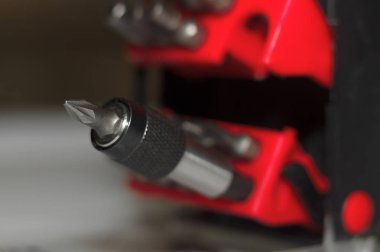 Kutuda parça tutucu ve beyaz arkaplanda bir sürü araç biti. Yakın çekim görüntüsü. Plastik kutuda kırmızı element.