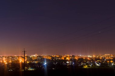 Uzun pozlu gece fotoğrafı. Önünde ağaçlar olan bir sürü yıldız. Şehirden uzakta. Gece manzarası.
