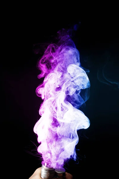 A hím kéz sűrű gőzködben vagy füstben tartja a gőzt. Vape felhők körül kéz a kézben, gőz a fekete háttér. A köd kettős színű kék és lila. Készlet izolált színes füst spray glicerin. — Stock Fotó