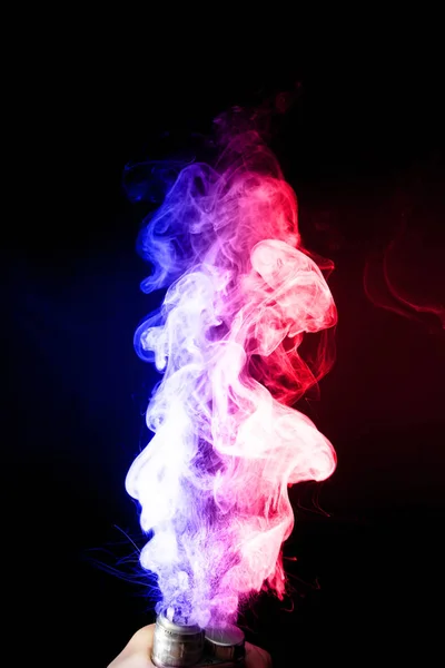 Male hand holds vape in thick vape fog or smoke. Vape clouds around hand with vape on black background. Fog is dual color  blue and purple. Stock isolated colorful smoke with spray glycerine. — Stock Photo, Image