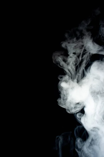 Mão masculina segura vape em névoa de vape grossa ou fumaça. Vape nuvens em torno da mão com vape no fundo preto. O nevoeiro é de cor dupla azul e roxo. Stock fumaça colorida isolada com glicerina spray. — Fotografia de Stock
