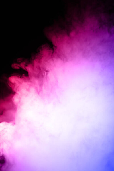 Male hand holds vape in thick vape fog or smoke. Vape clouds around hand with vape on black background. Fog is dual color blue and purple. Stock isolated colorful smoke with spray glycerine.