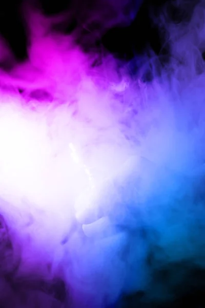 Male hand holds vape in thick vape fog or smoke. Vape clouds around hand with vape on black background. Fog is 2 color blue and purple. Stock isolated colorful smoke with spray glycerine. — Stock Photo, Image