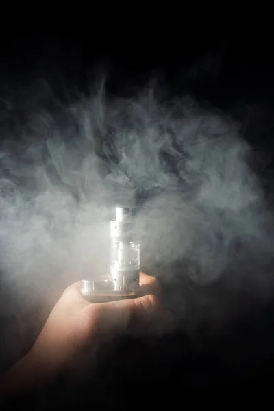 Tangan pria memegang vape dalam kabut vape tebal atau asap. Vape awan aro — Stok Foto