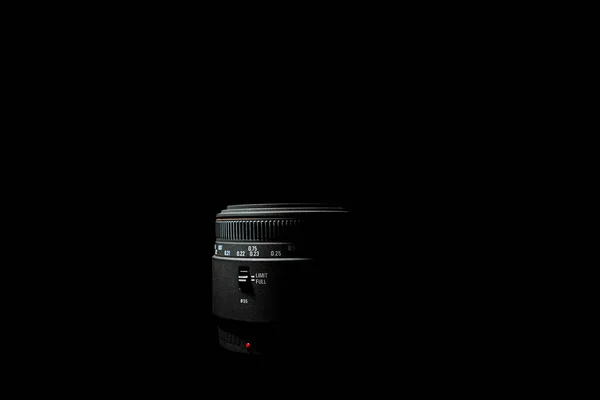 Foto não dereexposta da lente da câmera DSLR deitada no fundo preto. Foto de stock isolada. Foto de luz baixa e grande profundidade de campo. — Fotografia de Stock