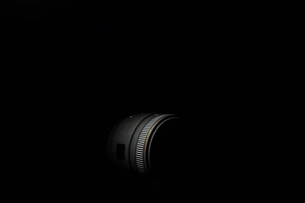 Foto não dereexposta da lente da câmera DSLR. Foto de stock isolada sobre fundo preto. Foto de luz baixa e grande profundidade de campo. — Fotografia de Stock
