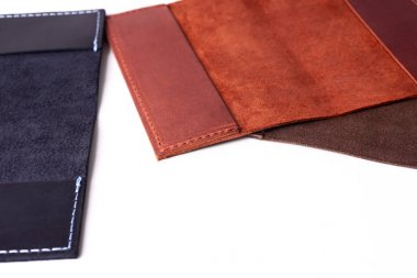 Üç el yapımı deri pasaport beyaz arka plan üzerinde izole kapsar. Yakın çekim görünümü. Kapaklar koyu mavi, kırmızı, kahverengi ve açık 