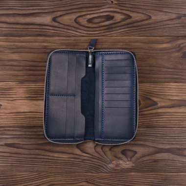 Ahşap desenli arka planda koyu mavi el yapımı deri porte-monnaie. Yağ tulumu. Görüş açımız düşük. Lüks aksesuarların stok fotoğrafı.