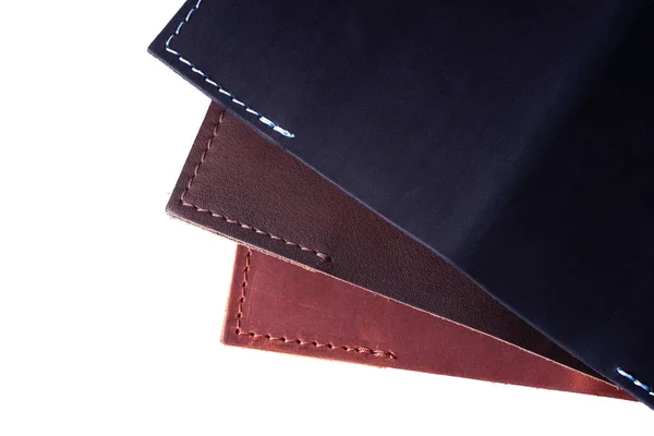 A parts of three handmade leather passport covers isolated on wh