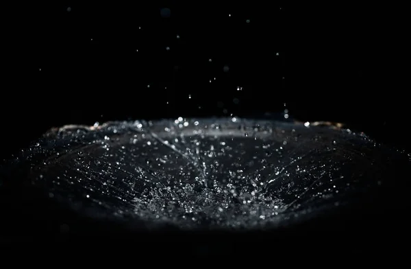 L'éclaboussure de l'eau tombe dans le haut-parleur sur fond noir. Pe — Photo