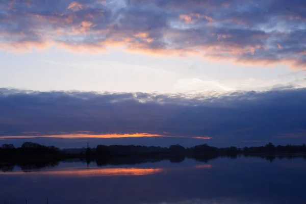 Pôr-do-sol vermelho sobre o lago ou rio. Roxo e azul clou — Fotografia de Stock