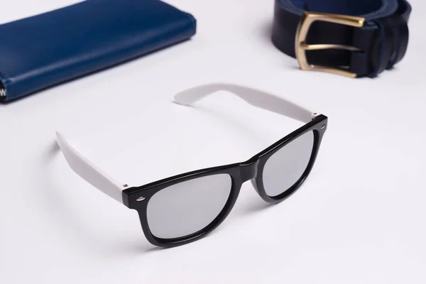 Mirror sunglasses on white background closeup. Leather wallet an