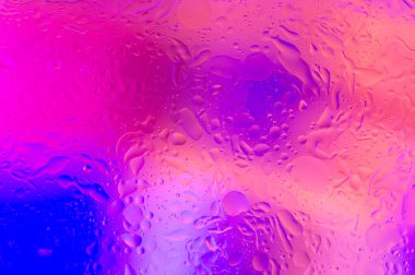 Yumuşak odak efektiyle suya yağ damlalarının mor soyut rengi.