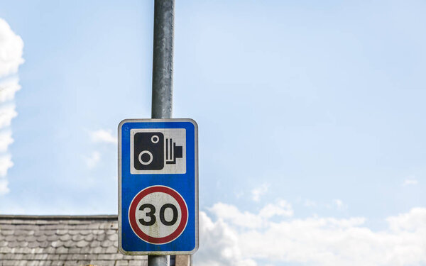 English traffic sign indicating maximum speed of 30 miles and camera recording, UK