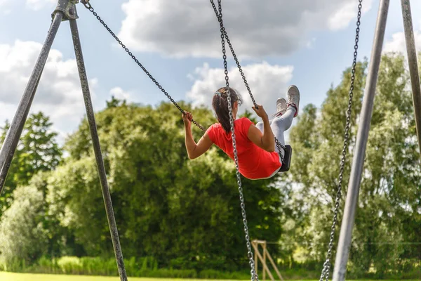 Vista Una Chica Con Una Camisa Roja Balanceándose Parque Lleno —  Fotos de Stock