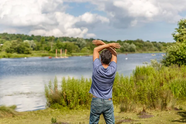 A man greets from the shore of a great river