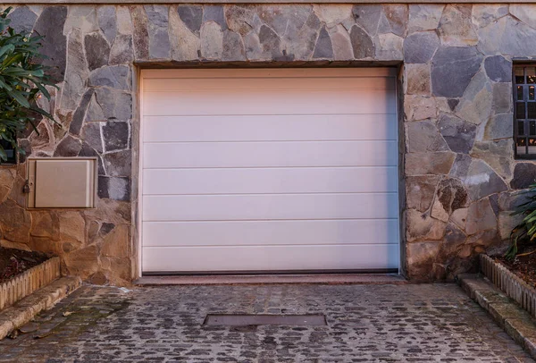Garage at the entrance at street level of a large stone house