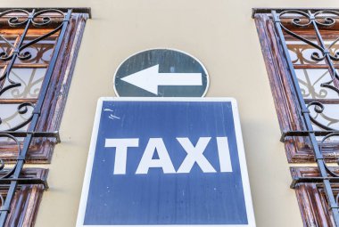 Taksi işareti iki pencere arasında bir duvar asılı durmak