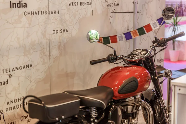 Motorbike travel next to a wall with a large map, exhibited at a fair