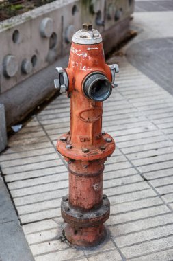 Bir şehirde itfaiye tarafından kullanılmaya hazır bir sokakta bulunan kırmızı musluğu