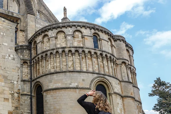 A tourist carefully observes the facade of part of the medieval style catholic cathedral in the city of Norwich, Norfolk, England