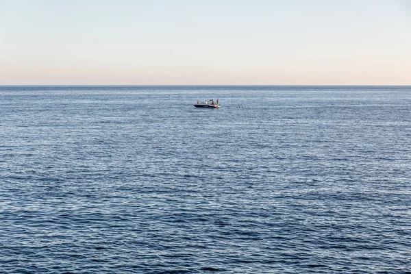 Distant view of a small lone boat in the middle of the sea