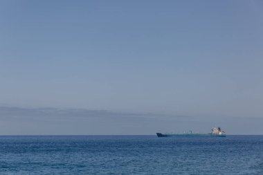 Açık bir gökyüzü, İspanya ile sakin bir denizde büyük bir uzak gemi görünümünü