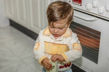 Sevimli bir çocuk bir kit içinde bir elektrikli fırın yanında yemek yaparken oynuyor