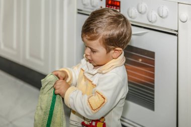 Sevimli bir çocuk bir kit içinde bir elektrikli fırın yanında yemek yaparken oynuyor