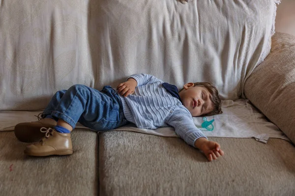 Красивый мальчик мирно спит на диване в гостиной — стоковое фото