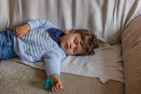 一个穿着蓝色衣服的温柔的幼儿男孩正在安安静静地休息 — 图库照片