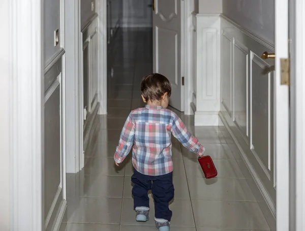 Дитина ззаду йде по коридору свого будинку — стокове фото