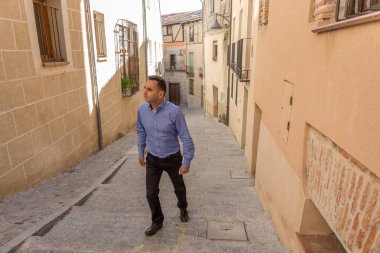 Mavi gömleğinde zarif bir adam, bir c eski bir parçası üzerinden yürür