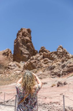 Olgun bir sarışın turist bazı volkanik kaya resimleri alıyor