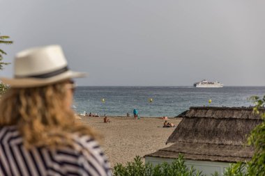 Bir yaz günü turistlerin bir plaj manzarası, bir woma tarafından izlenen