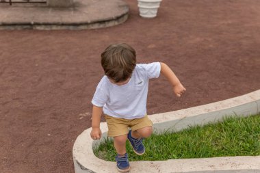 Sevimli sarışın çocuk bir parkta oynarken sahiptir