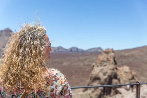 ブロンドの成熟した女性は、テイデで火山の風景を観察します — ストック写真