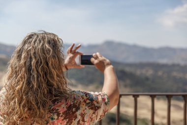 Olgun bir turist kadın bir manzara bir resim çekiyor