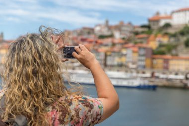 Sarışın bir turist kadın bir cep telefonu ile bir fotoğraf çeker
